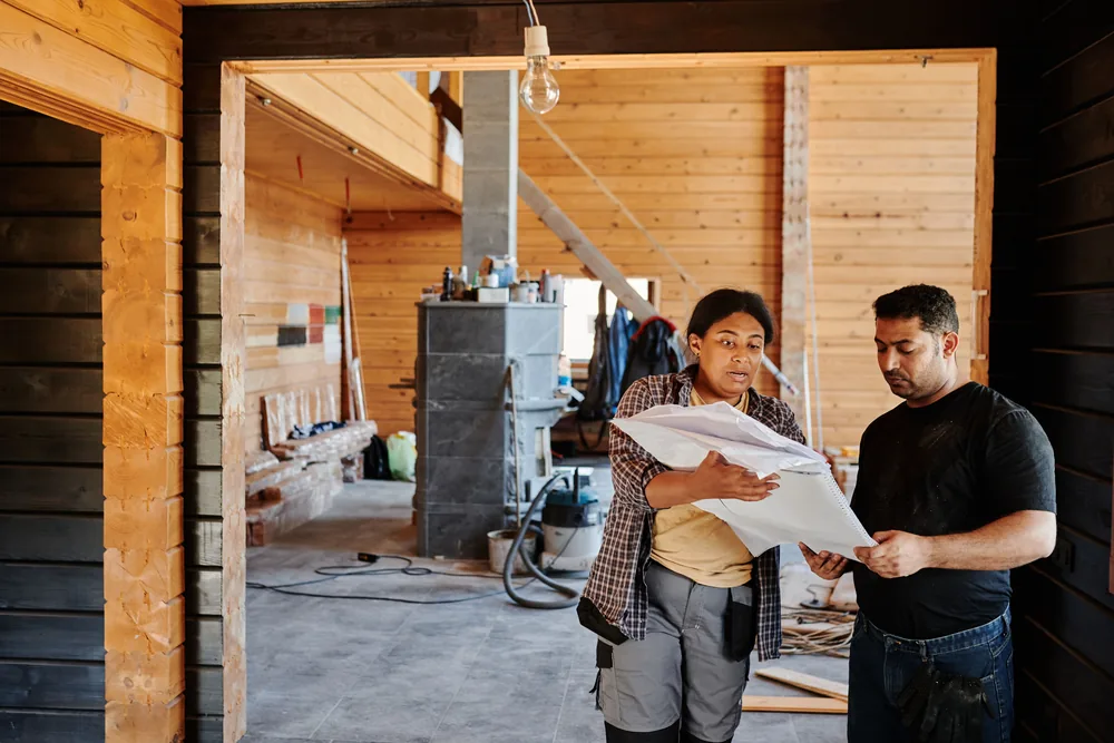 Terceirização na construção civil com equipe analisando planta da obra